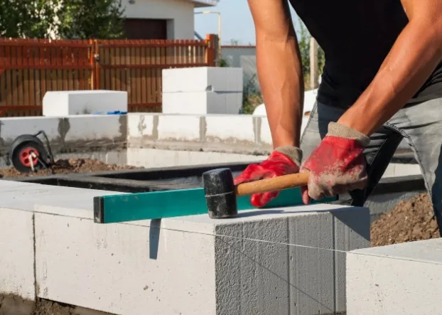 Albañil colocando bloques de hormigón en muro - Granada